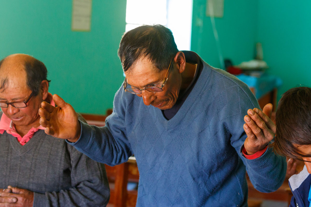 Elderly man praying.